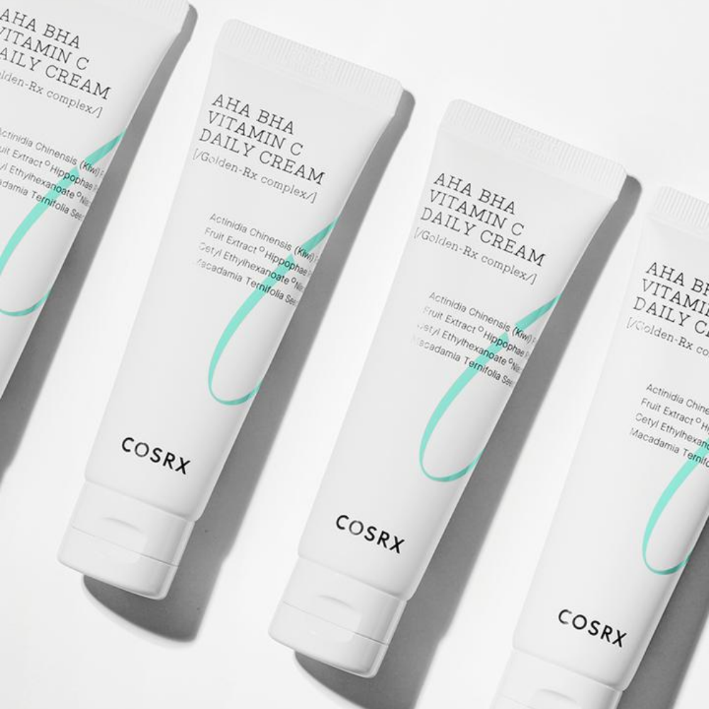 Fyra tuber COSRX Refresh AHA BHA Vitamin C Daily Cream 50ml på en vit yta.